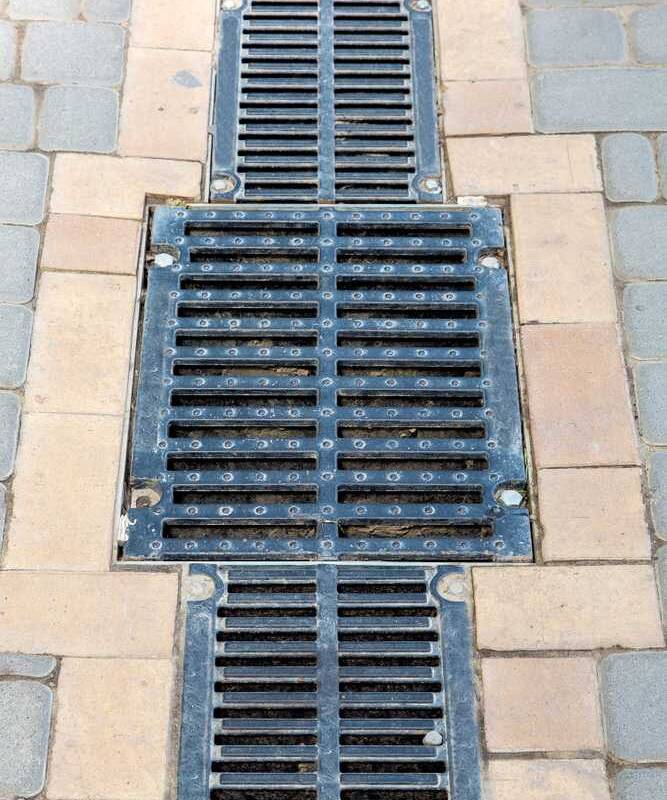 Driveway trench drain installed to prevent pooling and water damage in New Hampshire home
