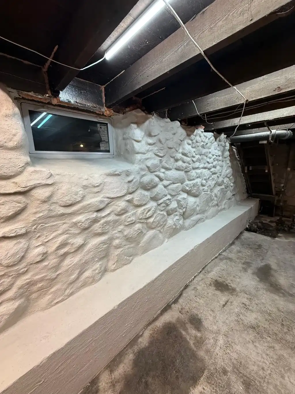 Basement wall with waterproofing treatment