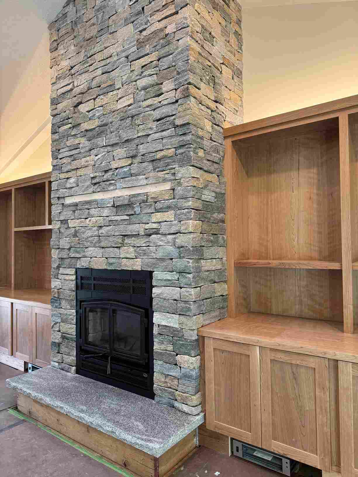 Stone fireplace veneer with granite hearth in Massachusetts