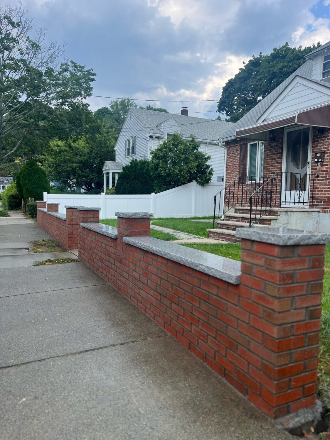 New brick wall separating house and sidewalk